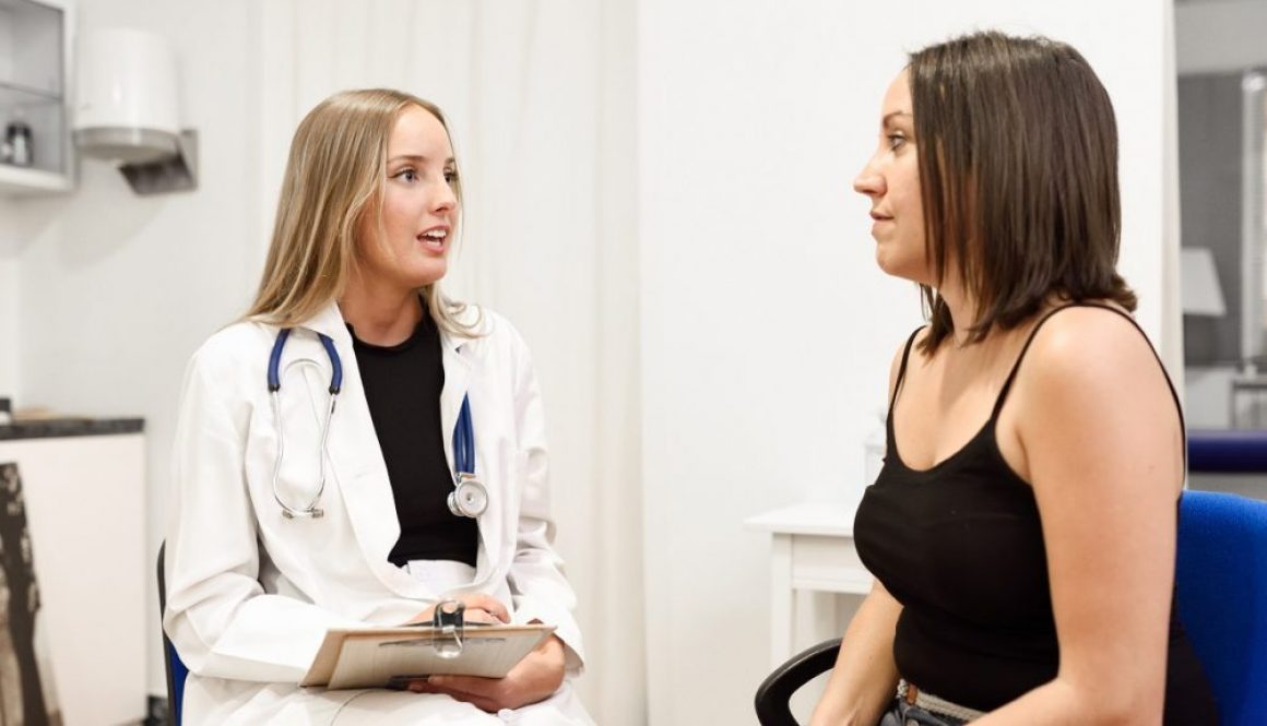 Female doctor explaining diagnosis to her young woman patient.